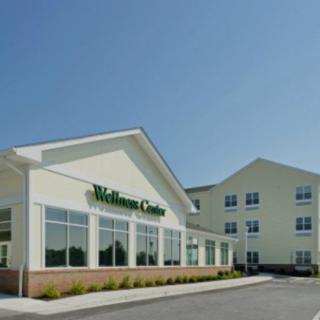A modern wellness center building with clear skies in the background.