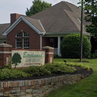 A welcoming entrance to a residential complex, featuring well-maintained landscaping.