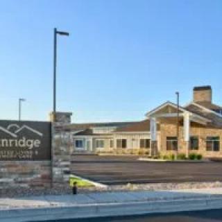 A modern facility with a stone sign and clear blue sky.
