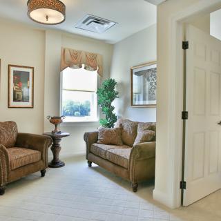 A cozy living room with matching sofas and armchairs, enhanced by soft lighting and elegant decor.