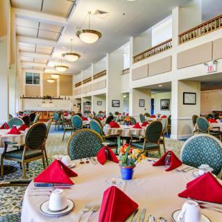 A spacious and elegantly decorated dining room with tables set for guests.