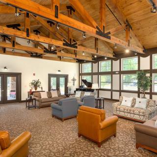 A spacious living room with modern furniture and a wooden ceiling.