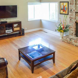 A cozy living room with a television, coffee table, and fireplace.