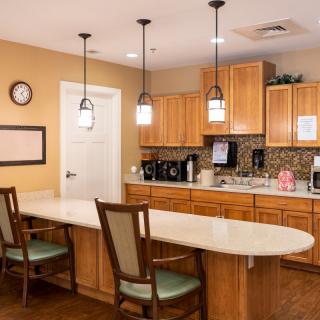 A cozy kitchen space with wooden cabinets, a long countertop, and pendant lighting.
