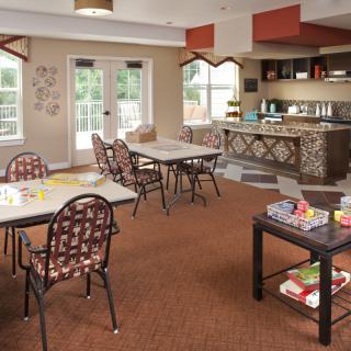 A cozy communal dining area with tables, chairs, and a small serving counter.