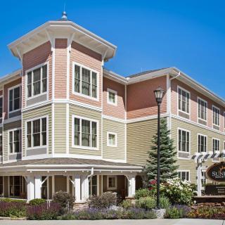 A multi-story residential building with colorful exterior design and surrounding landscaping.