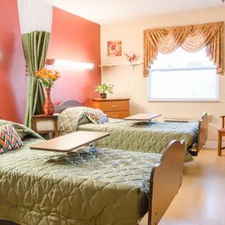 A cozy bedroom with two neatly made beds, warm lighting, and elegant decor.