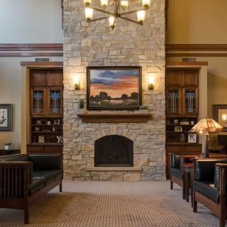 A cozy living room with a stone fireplace and elegant wooden furniture.