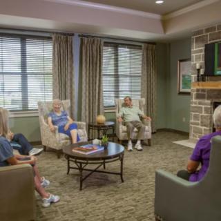 A group of people sitting in a cozy living room having a conversation.