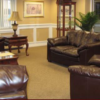 A cozy living room featuring leather sofas, a side table with a lamp, and tasteful decor.