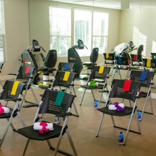 A well-organized room setup with chairs and fitness equipment for a workshop.
