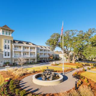 A beautiful hotel surrounded by landscaped gardens and a clear blue sky.