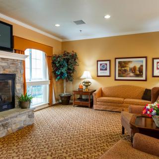 A cozy living room with a fireplace and warm decor, featuring a comfortable sofa and a television.