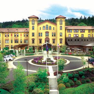 A luxurious hotel surrounded by lush greenery and a landscaped entrance.