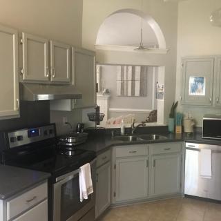 A modern kitchen with light-colored cabinets and stainless steel appliances.