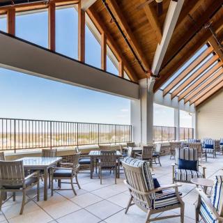 A spacious patio with modern seating, offering views through large windows.
