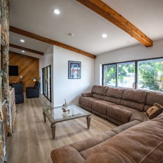 A modern living room with comfortable sofas, a glass coffee table, and large windows letting in natural light.