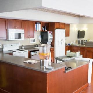 A modern kitchen with wood cabinets and various appliances.