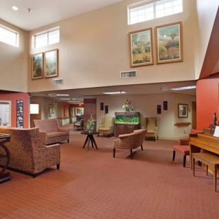 A spacious lobby with comfortable seating, artwork, and natural lighting.