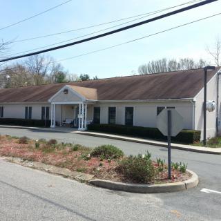 A suburban building with a small road and landscaped area in front.