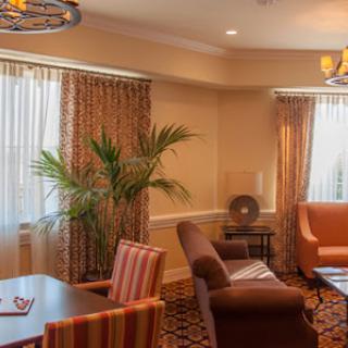 A cozy and elegantly designed living room featuring comfortable seating, warm lighting, and decorative curtains.