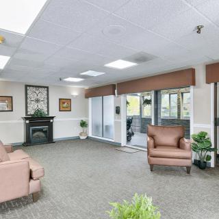 A spacious lobby area with comfortable armchairs, a fireplace, and large windows.