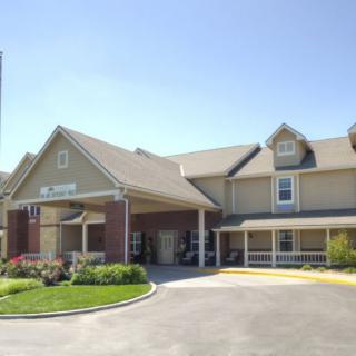 A building with a covered entrance and landscaped surroundings.