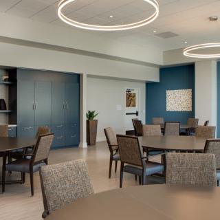 A modern interior dining area or meeting room with circular lighting fixtures and stylish furniture.
