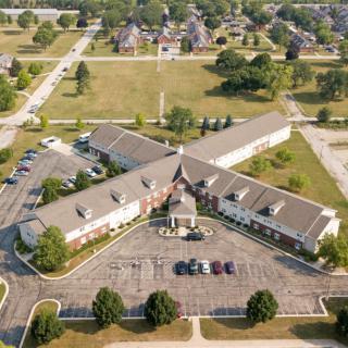 Aerial view of a suburban building with surrounding roads and parking areas.