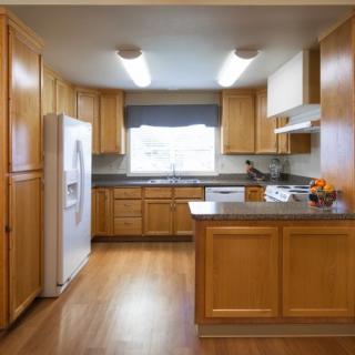 A modern kitchen with wooden cabinets and bright lighting.