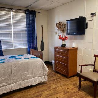 A cozy and inviting bedroom with a television, wooden furniture, and decorative accents.