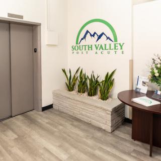 A welcoming reception area featuring an elevator, decorative plants, and a company logo.