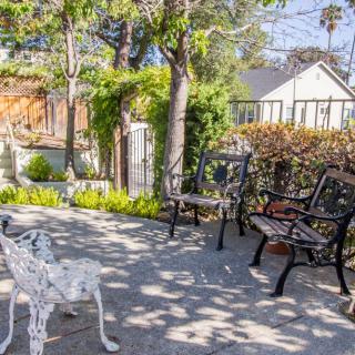 A serene outdoor patio area with benches and dappled sunlight filtering through the trees.