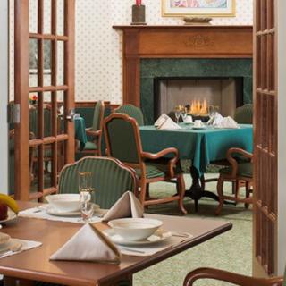 A cozy restaurant dining room with a fireplace and elegantly set tables.