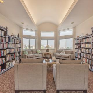 A cozy living room library with bookshelves and comfortable seating.