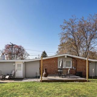 A single-story house with a backyard deck on a sunny day.