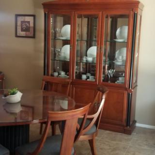 Elegant dining room with a wooden china cabinet and table set.
