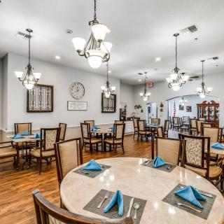 A well-lit dining area with neatly arranged tables and chairs, ready for guests.