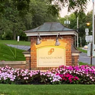 A welcoming entrance sign adorned with vibrant flowers.
