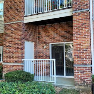 A view of an apartment building featuring a brick facade and a balcony.