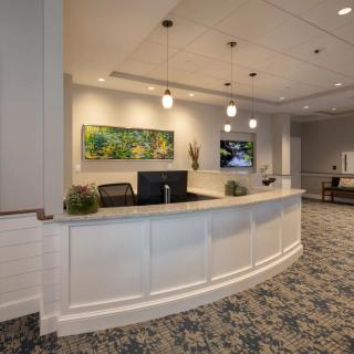 A modern reception area with a curved desk and decorative artwork.