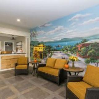 A cozy waiting area with comfortable seating and a vibrant mural depicting a scenic landscape.