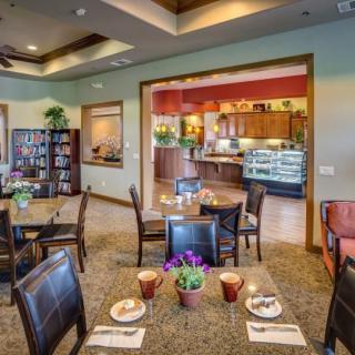 A cozy dining area with neatly arranged tables and chairs, featuring warm lighting and inviting decor.