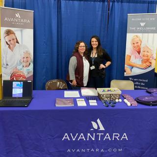 Healthcare event booth showcasing Avantara services with two representatives.