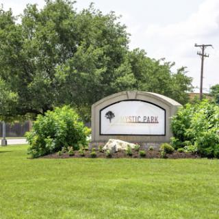 Welcome sign to a park surrounded by lush greenery.