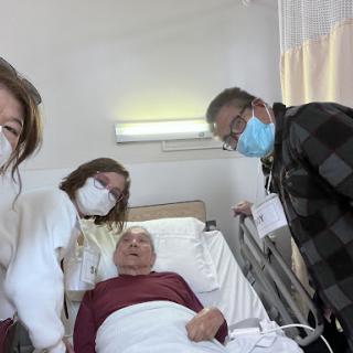 A family visit in the hospital, showing support for a loved one.