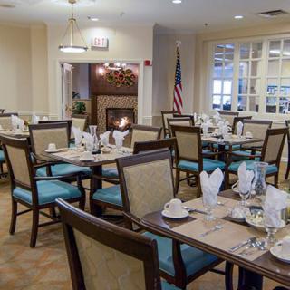 An elegantly set dining room with neatly arranged tables and chairs.