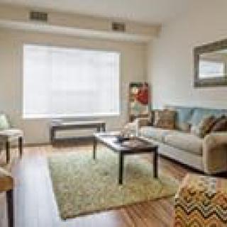 A cozy living room with a sofa, coffee table, and large window.