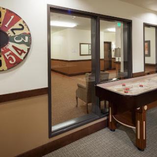 A view of a recreational area featuring a shuffleboard table and a colorful wheel.