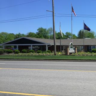 A view of a building with flags in front, set against a clear blue sky.